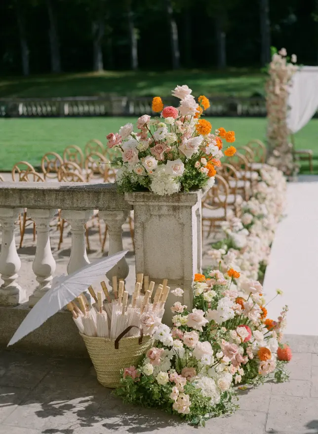 Décoration de cérémonie de mariage en extérieur avec compositions florales élégantes et mise en scène raffinée